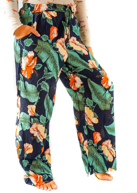 A pair of XS-M Leaf Print Pants for women, featuring a vibrant leaf pattern, drawstring waist, and two side pockets, made from lightweight rayon fabric.