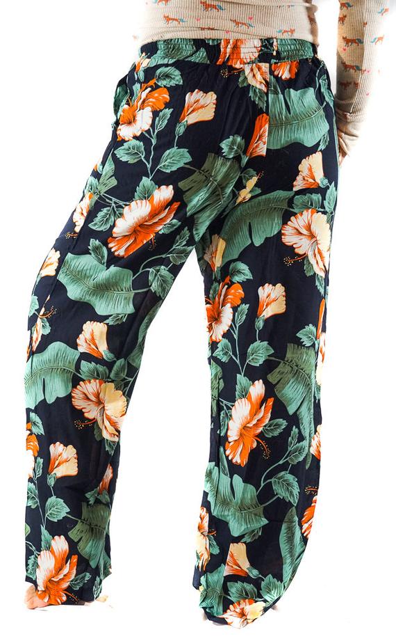 A pair of XS-M Leaf Print Pants for women, featuring a vibrant leaf pattern, drawstring waist, and two side pockets, made from lightweight rayon fabric.
