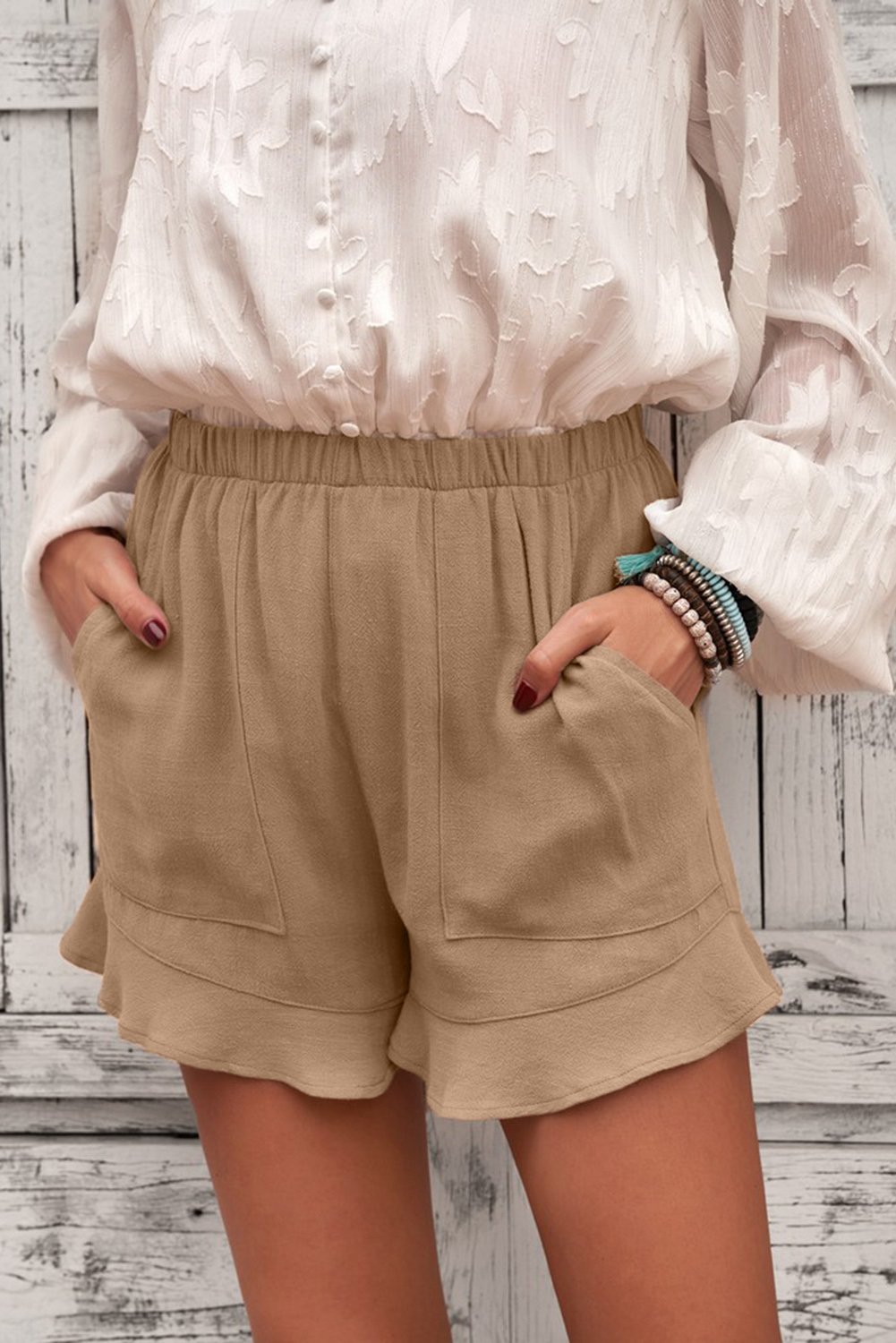A pair of women's khaki shorts featuring ruffled details and side pockets, made from breathable linen cotton blend, perfect for summer wear.