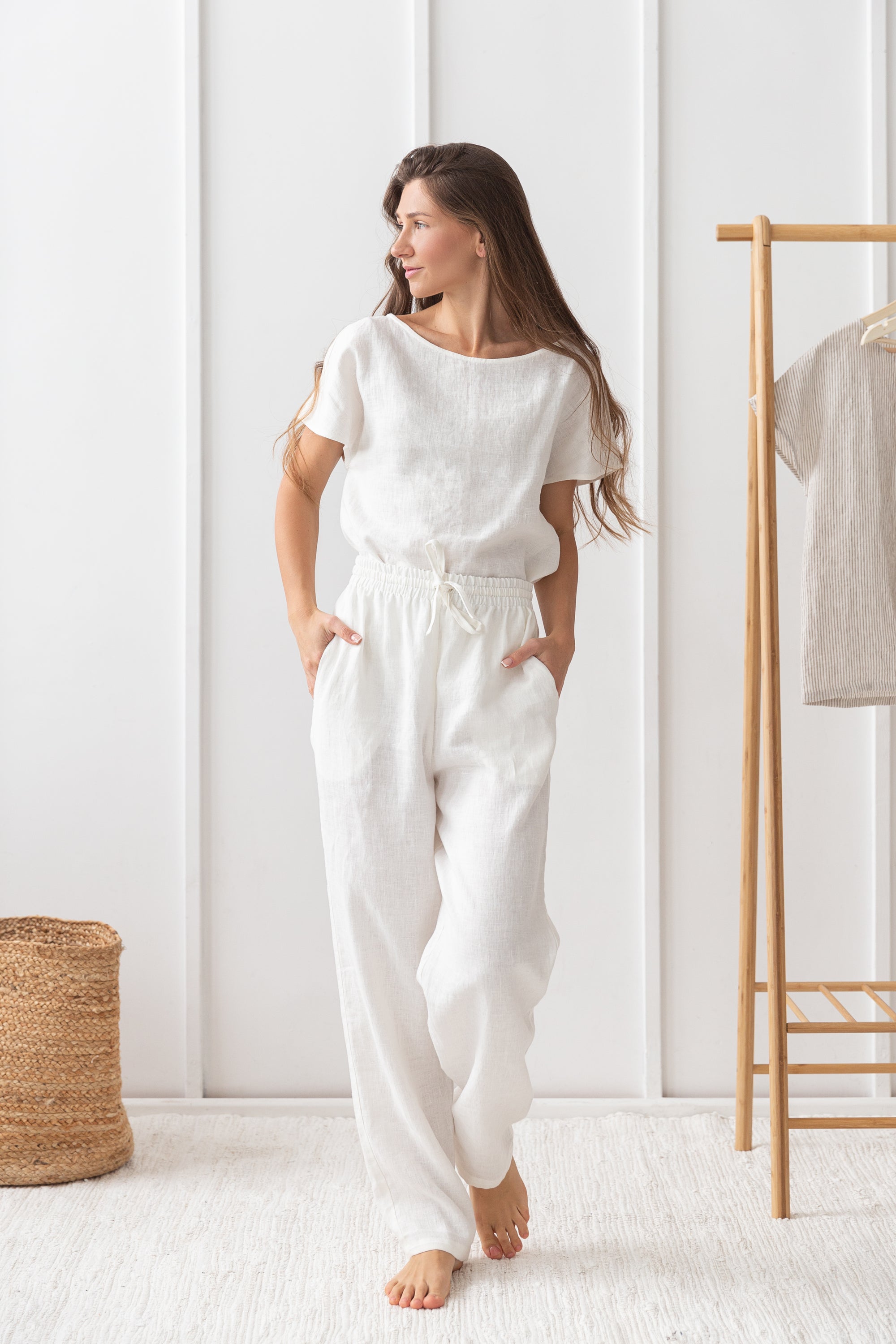 Elegant white linen pajama set featuring a boat neckline, short sleeves, and long pants with an adjustable waistband, perfect for lounging.