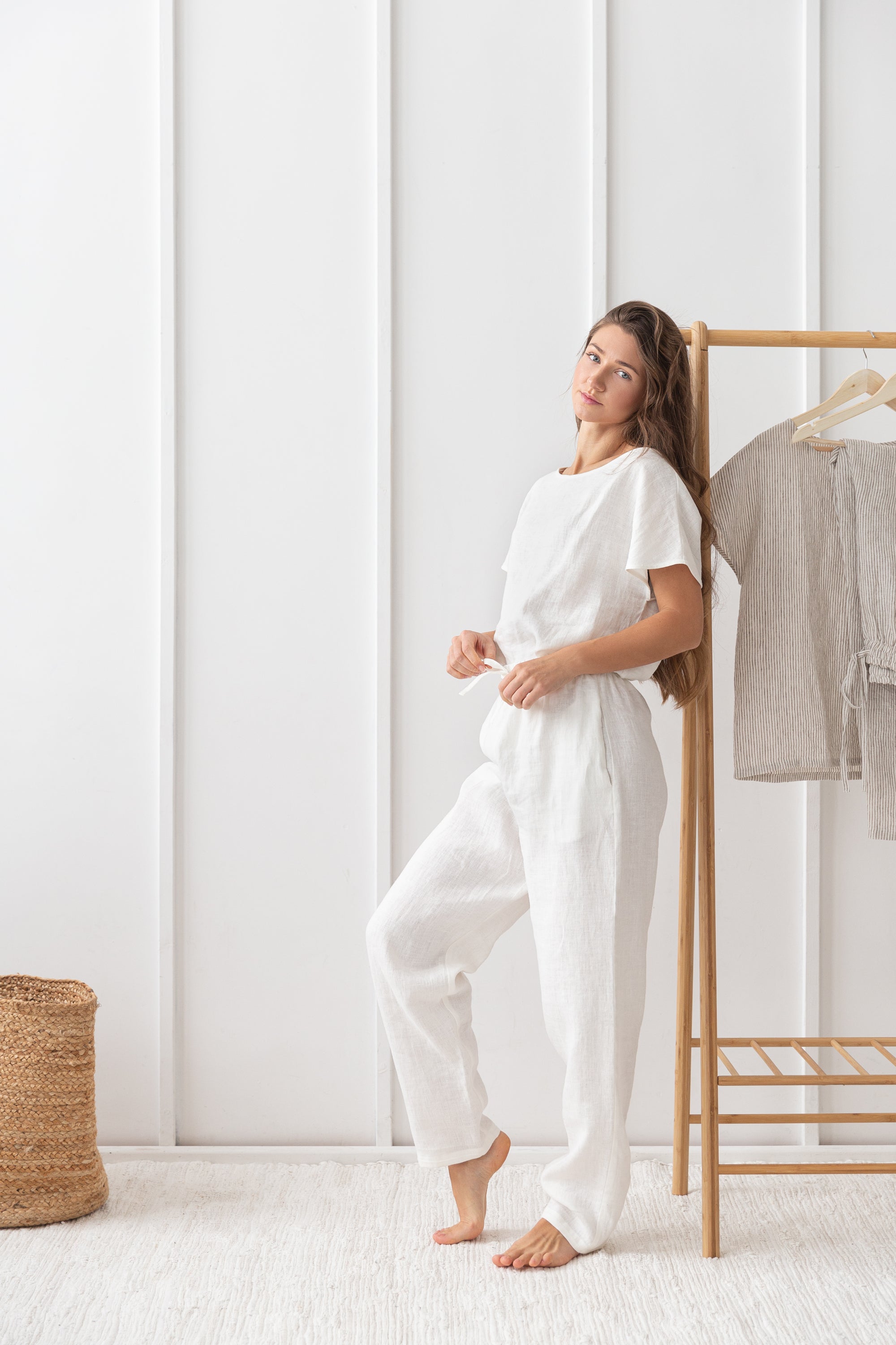 Elegant white linen pajama set featuring a boat neckline, short sleeves, and long pants with an adjustable waistband, perfect for lounging.