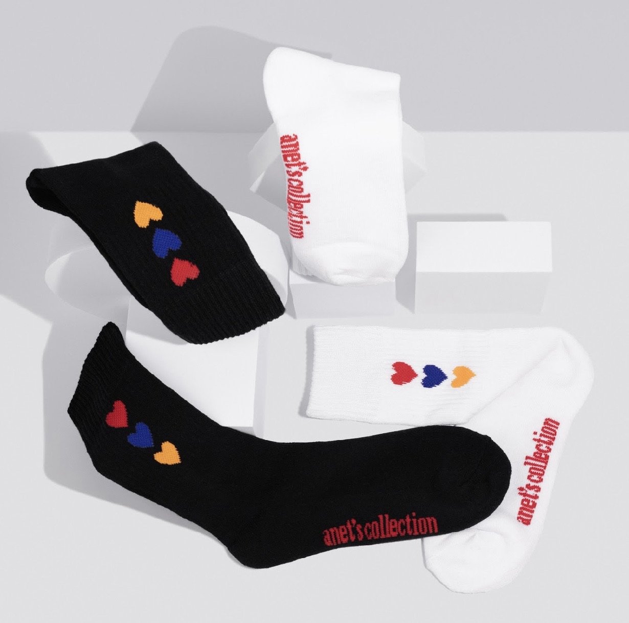 Hearts of Armenia Socks featuring jacquard design with red, orange, and blue hearts on a black and white background.