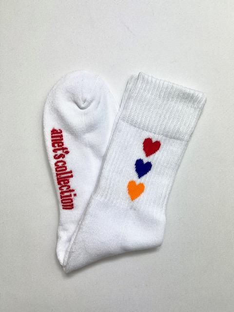 Hearts of Armenia Socks featuring jacquard design with red, orange, and blue hearts on a black and white background.