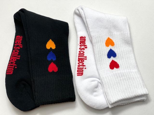 Hearts of Armenia Socks featuring jacquard design with red, orange, and blue hearts on a black and white background.