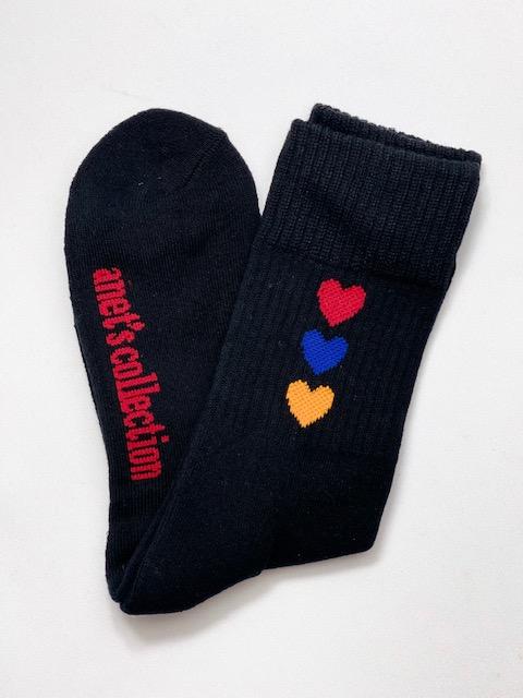 Hearts of Armenia Socks featuring jacquard design with red, orange, and blue hearts on a black and white background.