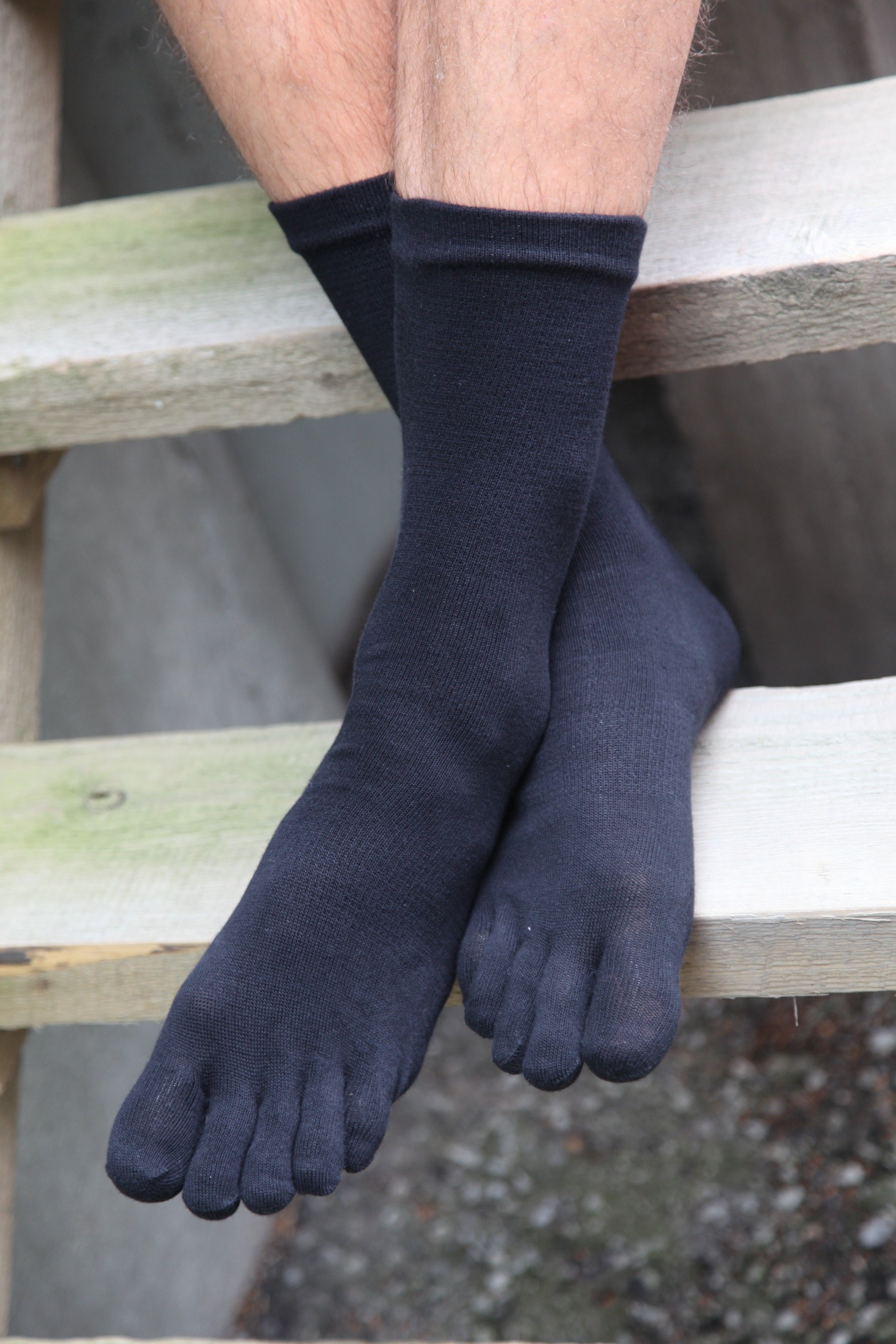 A pair of MEN TOES black toe socks made from soft cotton, featuring individual toe compartments for comfort and breathability.