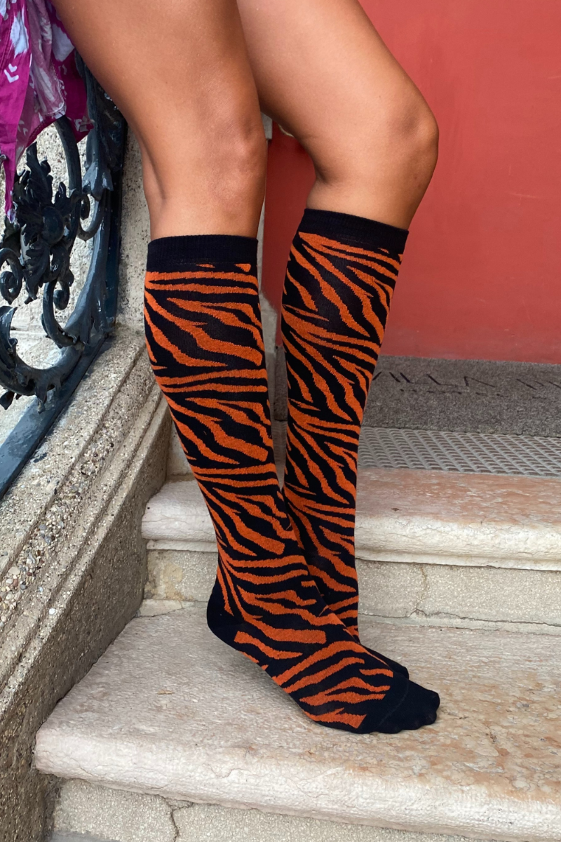 TIGER knee-highs featuring a vibrant tiger pattern in black and orange, showcasing elegant stripes.