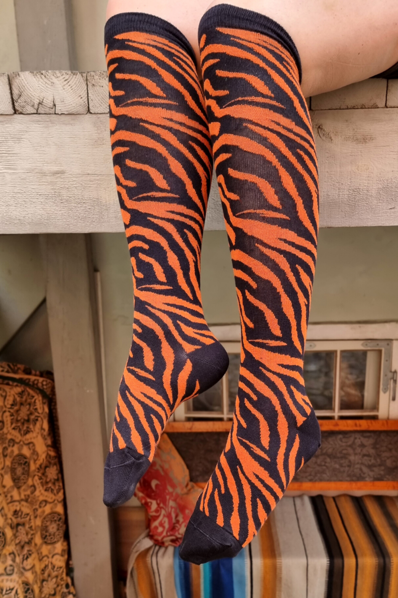 TIGER knee-highs featuring a vibrant tiger pattern in black and orange, showcasing elegant stripes.