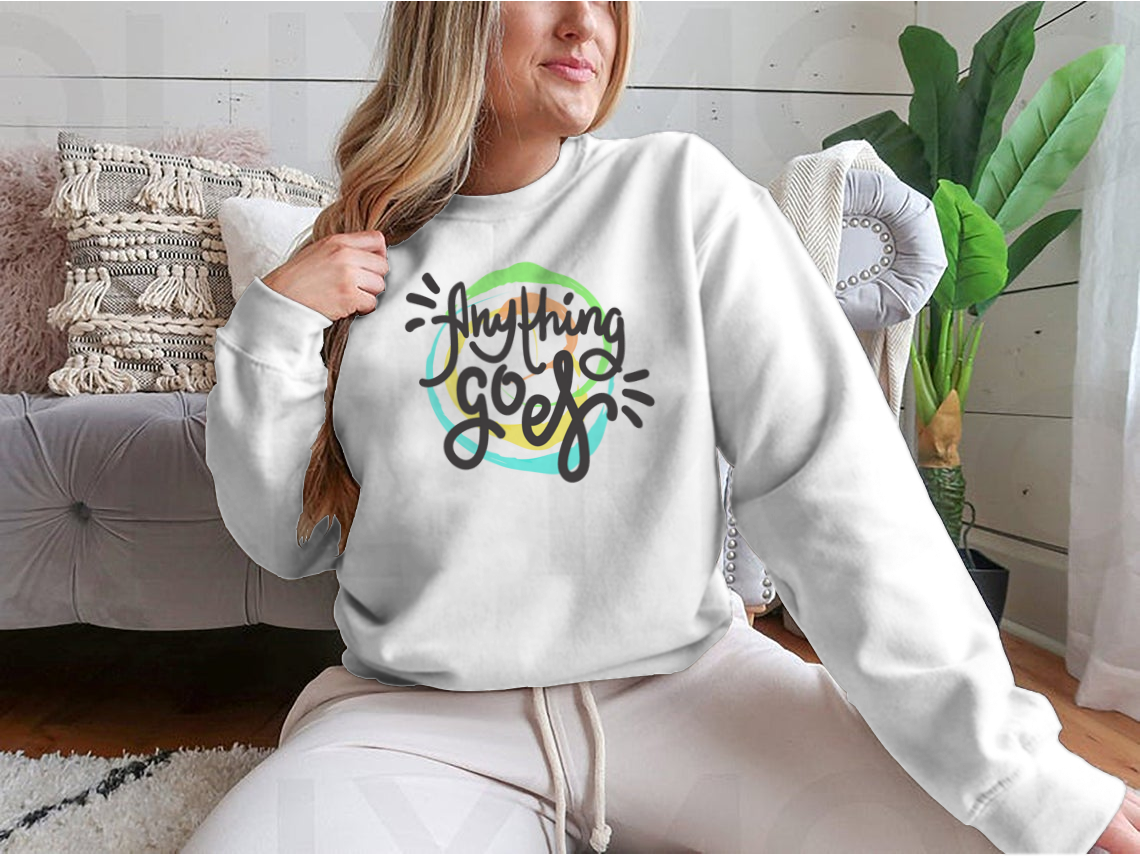 A hand-drawn motivational quote t-shirt featuring the phrase 'Anything Goes', made from 100% cotton, displayed on a neutral background.
