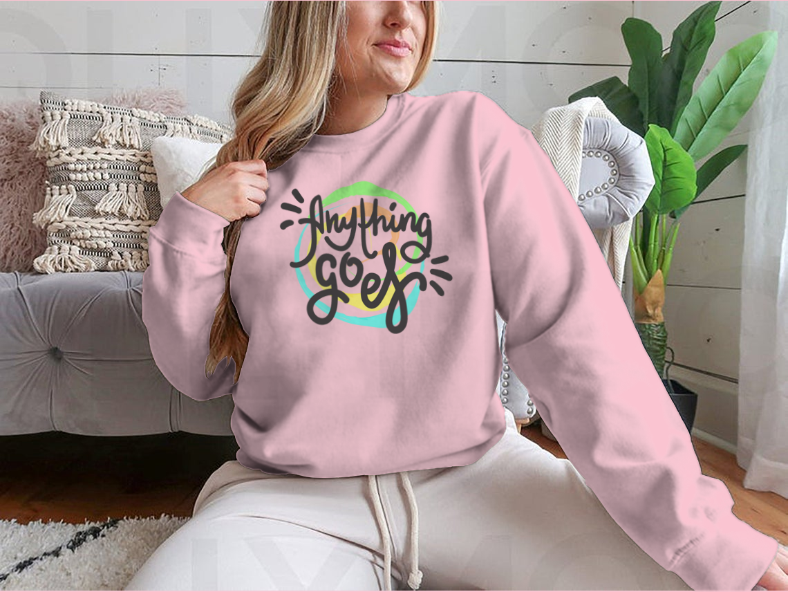 A hand-drawn motivational quote t-shirt featuring the phrase 'Anything Goes', made from 100% cotton, displayed on a neutral background.