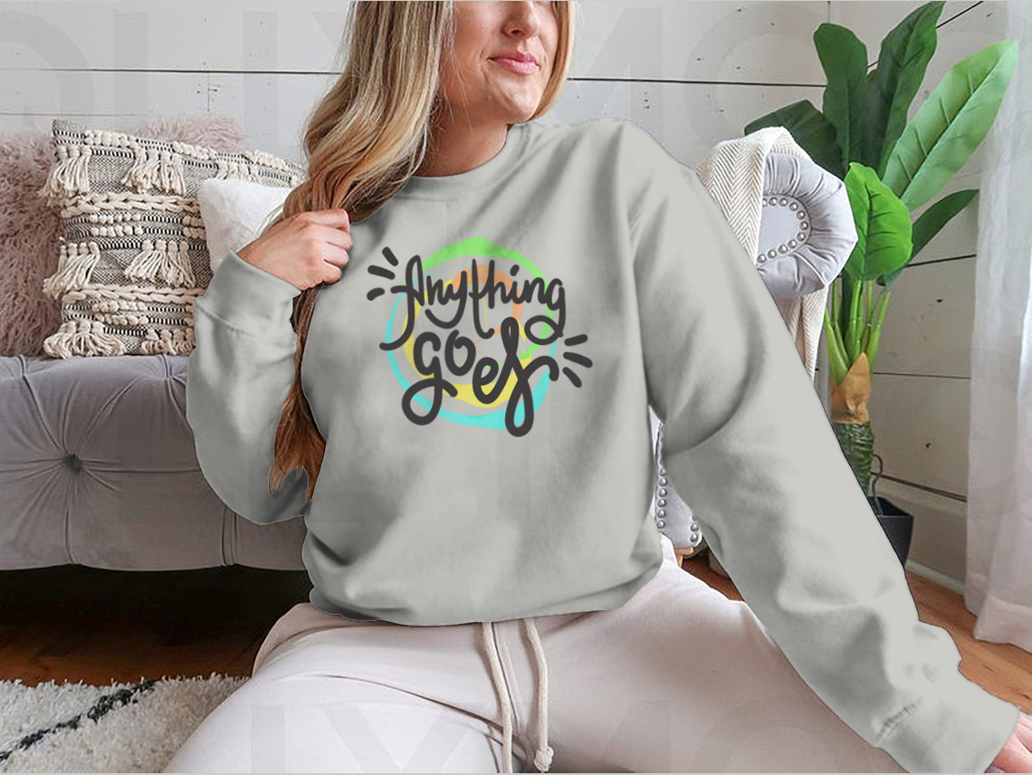 A hand-drawn motivational quote t-shirt featuring the phrase 'Anything Goes', made from 100% cotton, displayed on a neutral background.