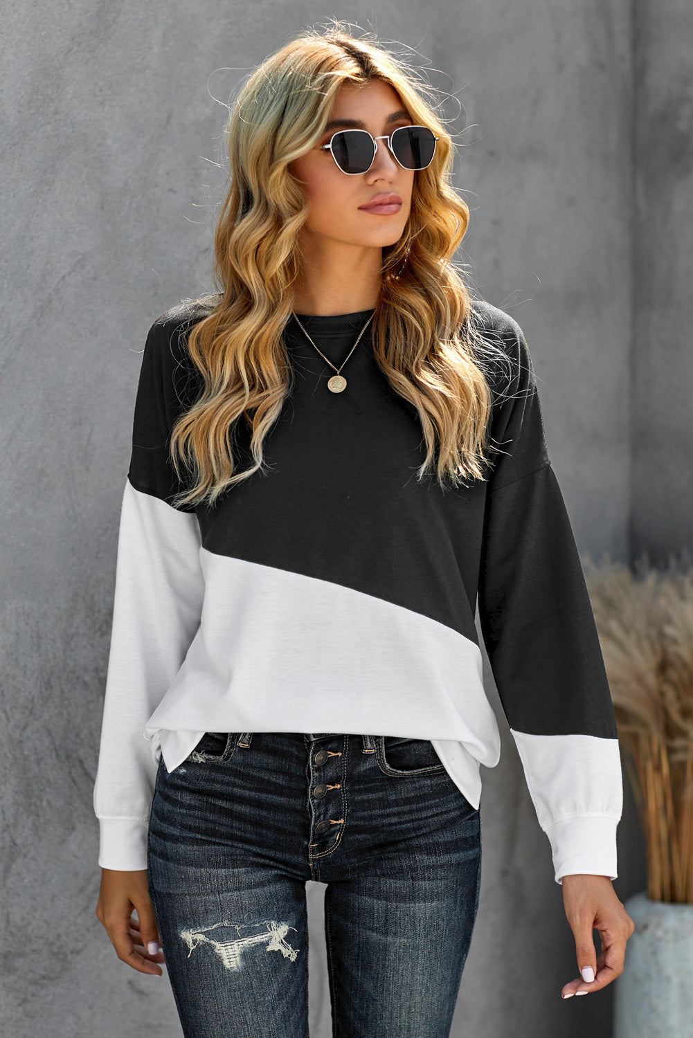 Black and white patchwork sweatshirt with dropped shoulder sleeves, showcasing a trendy color block design.