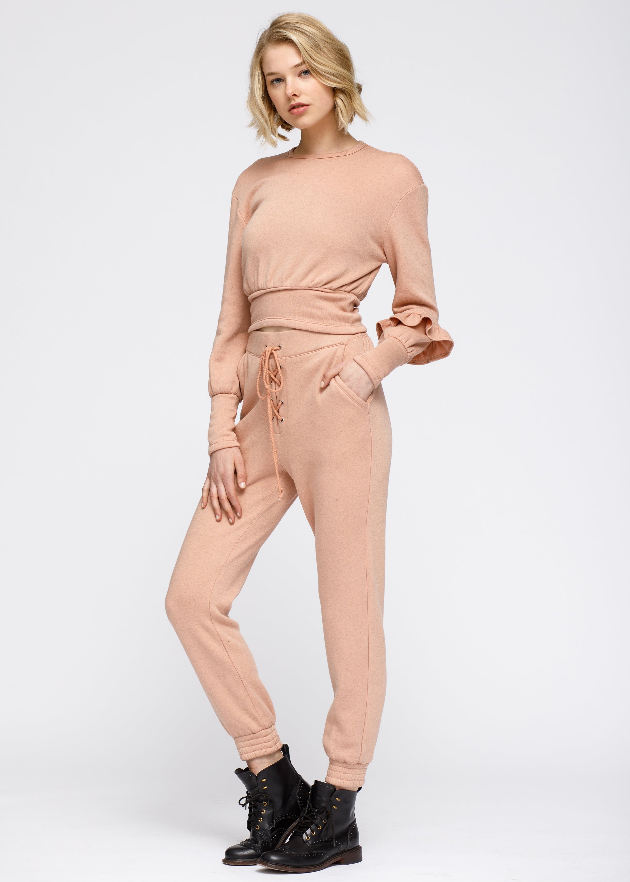 Peach crewneck sweatshirt with ruffle sleeve and elasticized waist, showcasing a stylish and comfortable design.