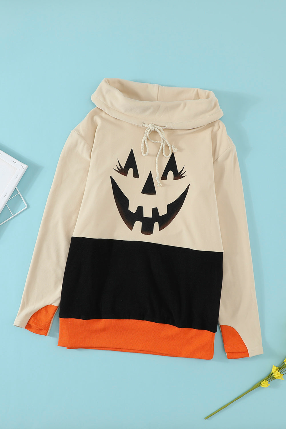 Cute black sweatshirt featuring a cowl neck and pumpkin print, perfect for Halloween celebrations.