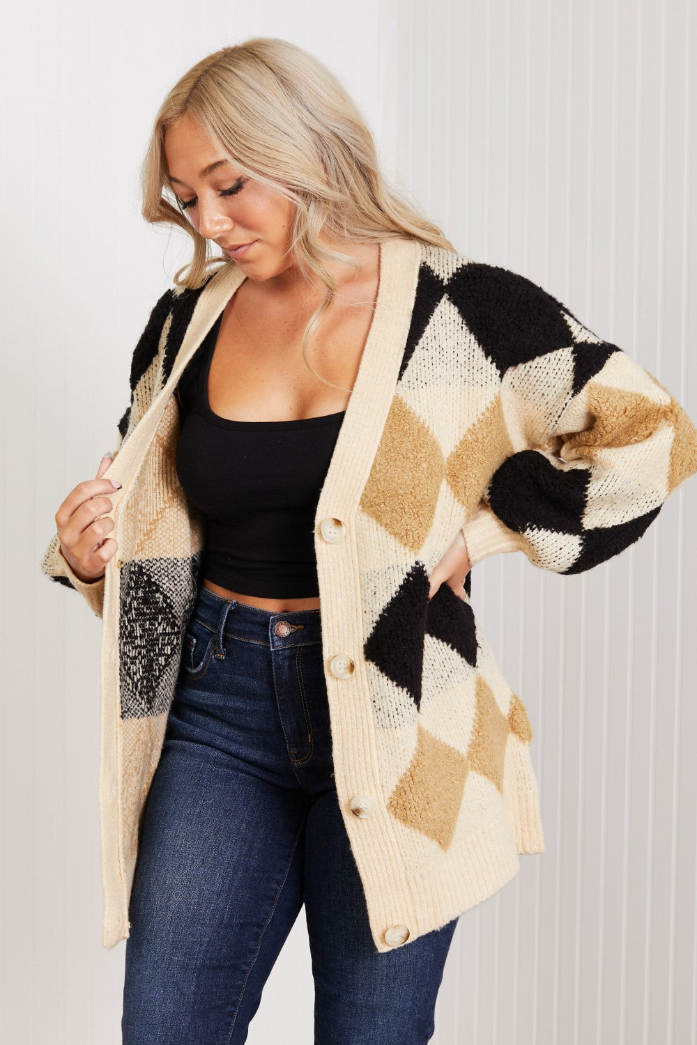 A cozy longline cardigan featuring a classic argyle pattern, button-front closure, and puffy balloon sleeves, perfect for autumn fashion.
