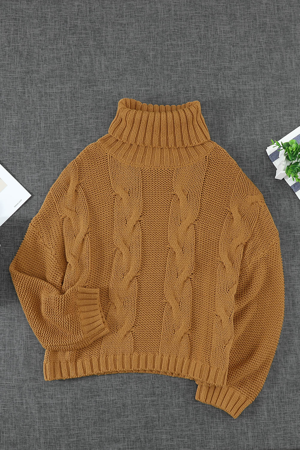 A cozy orange cable knit turtleneck sweater with an oversized fit, perfect for winter wear.