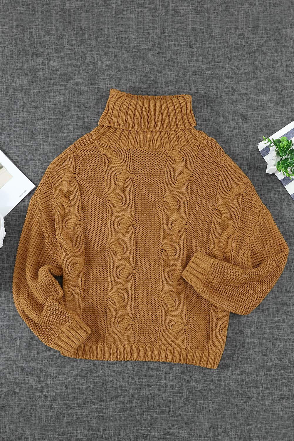 A cozy orange cable knit turtleneck sweater with an oversized fit, perfect for winter wear.