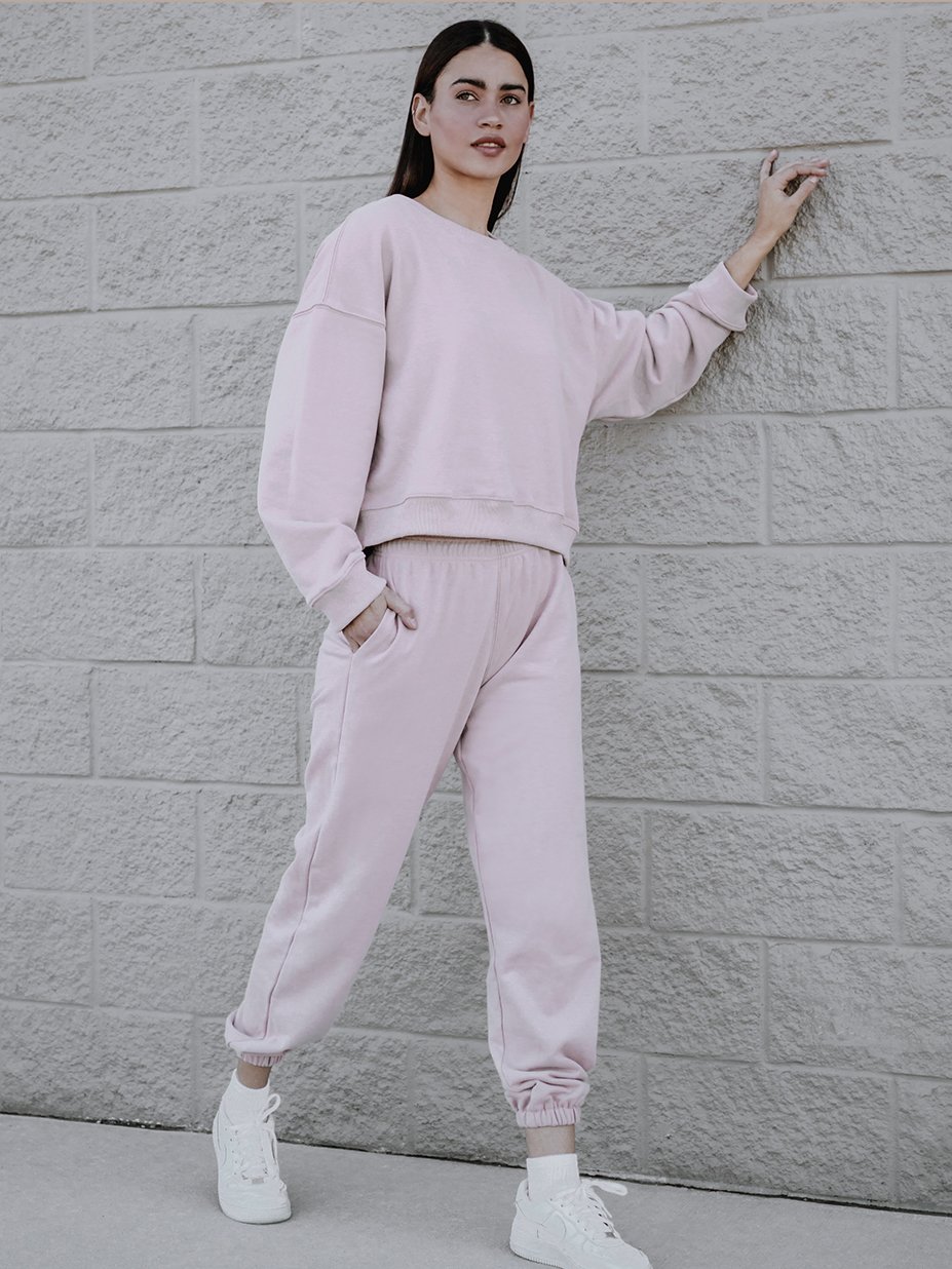 A soft pink sweatshirt with a rounded neckline and ribbed trim, showcasing a trendy boxy silhouette.