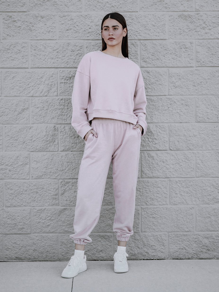 A soft pink sweatshirt with a rounded neckline and ribbed trim, showcasing a trendy boxy silhouette.