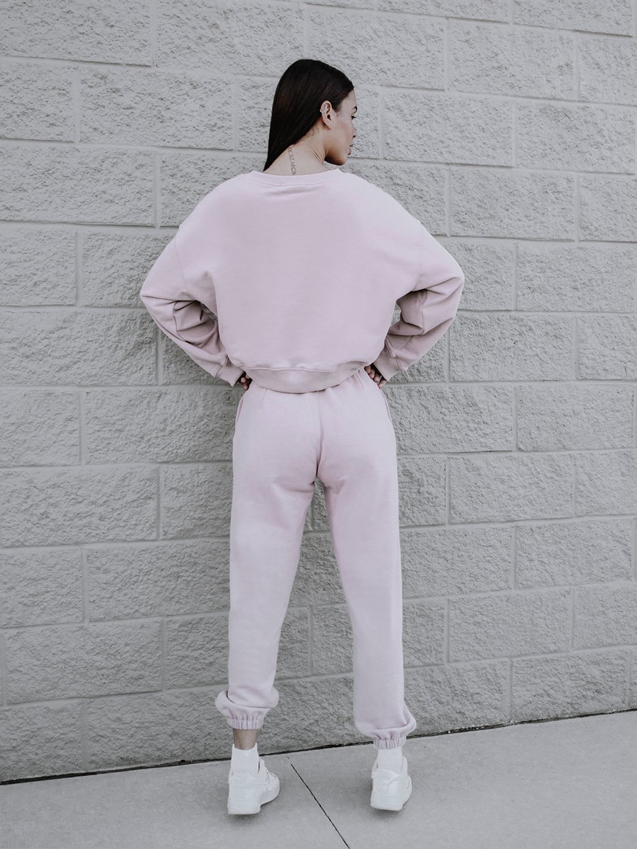 A soft pink sweatshirt with a rounded neckline and ribbed trim, showcasing a trendy boxy silhouette.