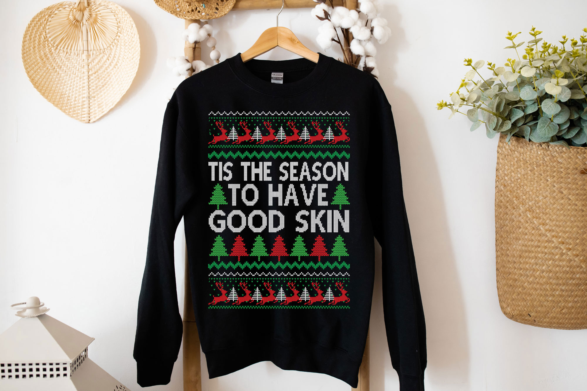 A cozy Gildan crewneck sweatshirt featuring the festive phrase 'Tis the Season to have Good Skin, perfect for Christmas celebrations.
