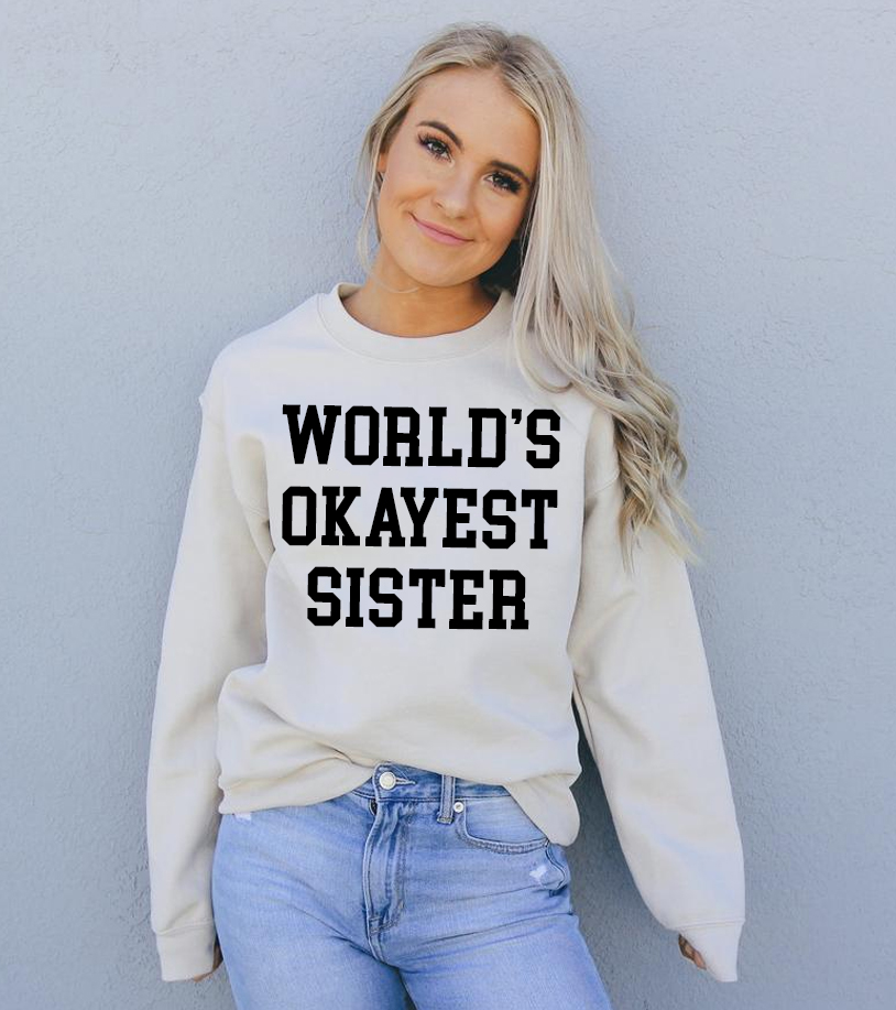 A cozy unisex sweatshirt featuring the phrase 'World's Okayest Sister' in a fun font, perfect for casual wear.