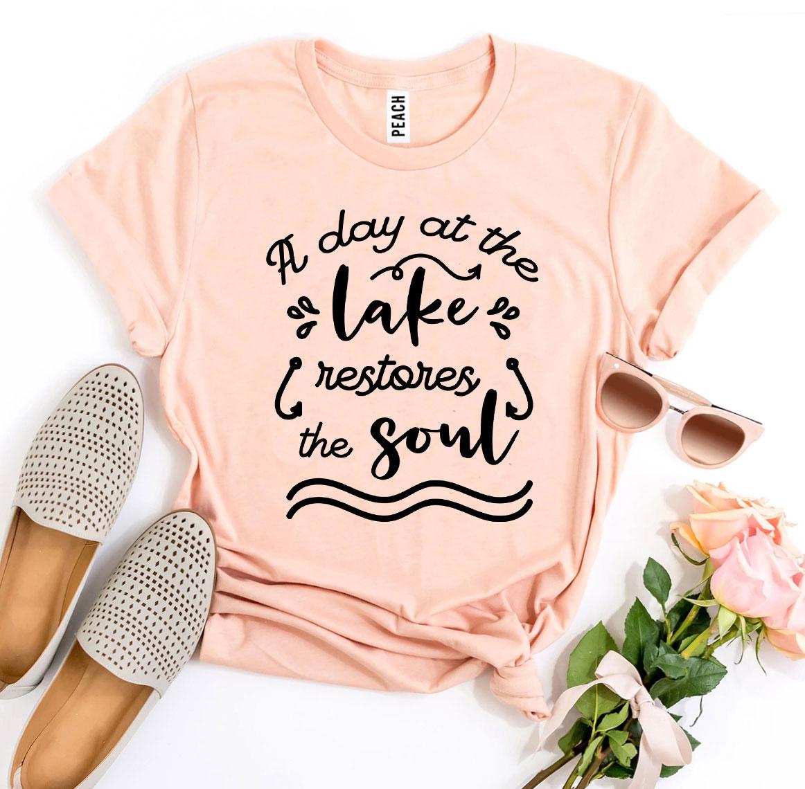 A Day At The Lake Restores The Soul T-shirt in soft ring spun cotton with a vibrant print, showcasing a serene lake scene.