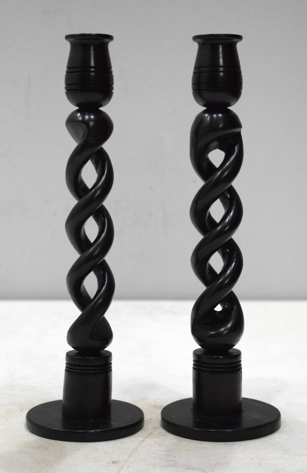 A pair of elegant African Twisted Ebony wood candle holders, showcasing intricate craftsmanship and a unique twisted design.
