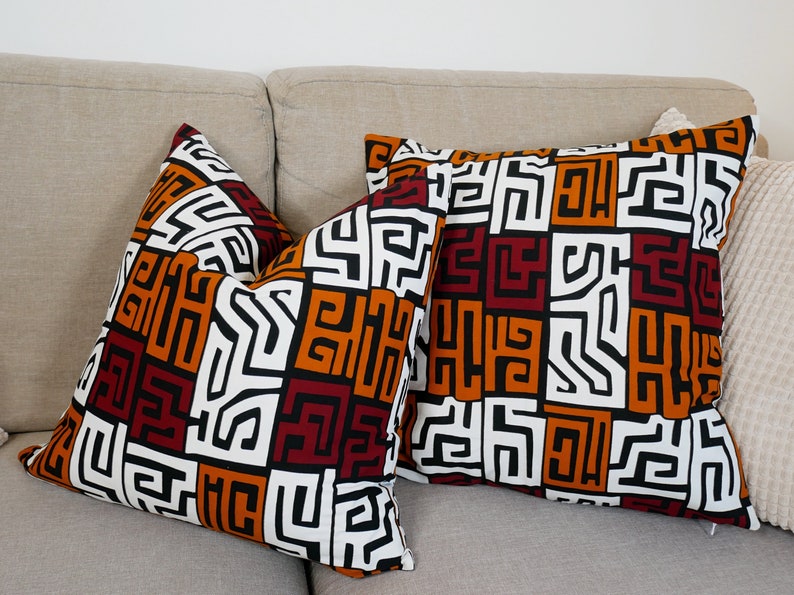 A pair of handmade African mudcloth pillow covers featuring intricate tribal patterns on soft cotton fabric, perfect for home decor.