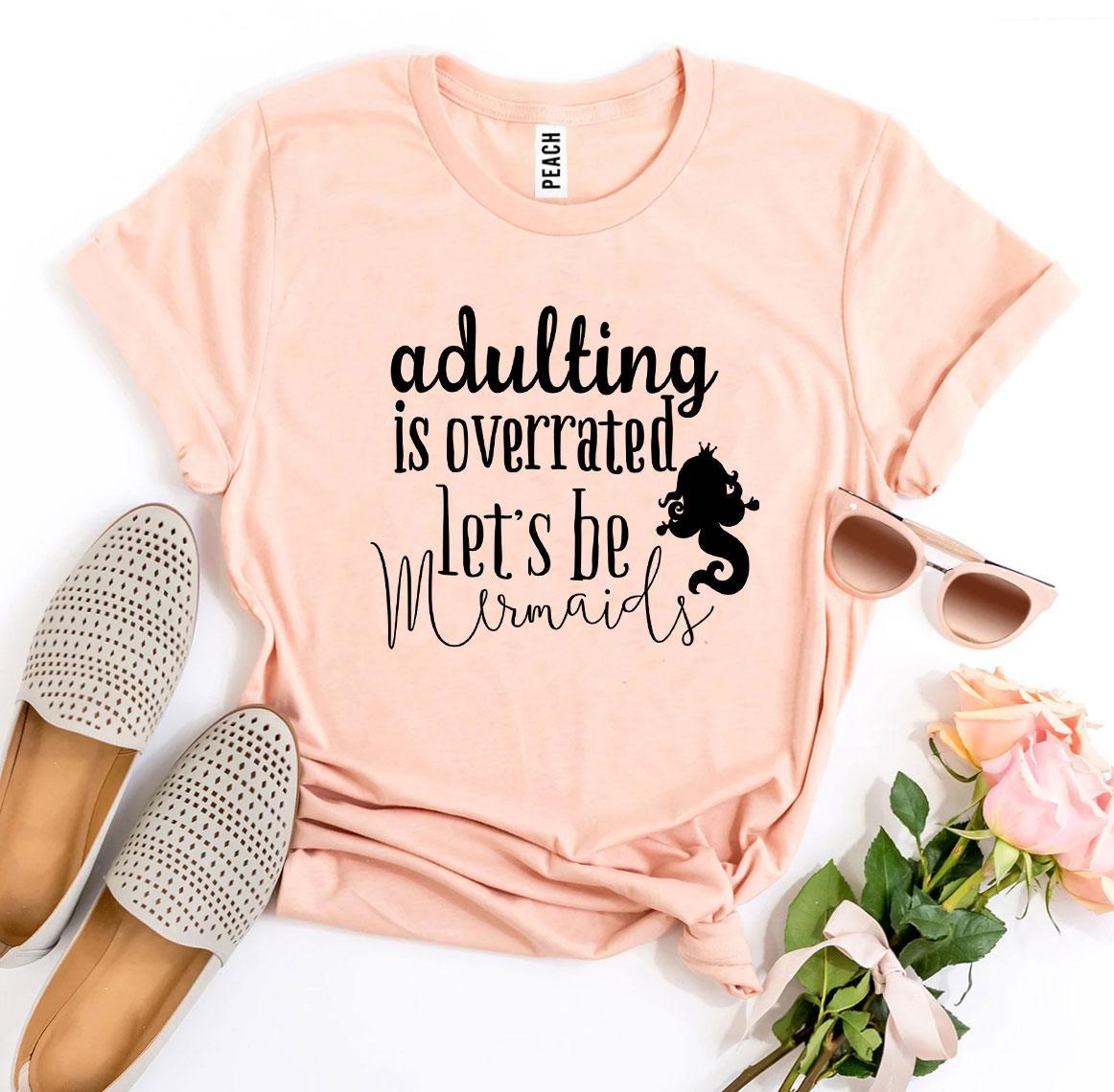 A soft, premium quality T-shirt featuring the phrase 'Adulting Is Overrated Let’s Be Mermaids' in a playful design.