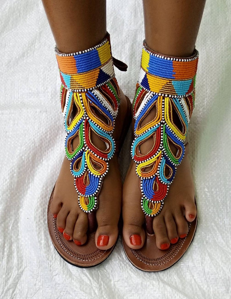 A pair of African Maasai sandals featuring colorful beadwork on soft leather, designed for comfort and style.
