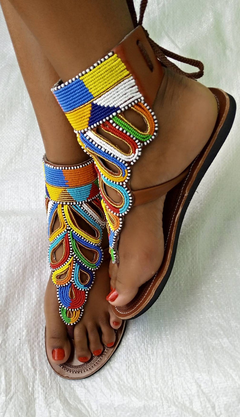A pair of African Maasai sandals featuring colorful beadwork on soft leather, designed for comfort and style.