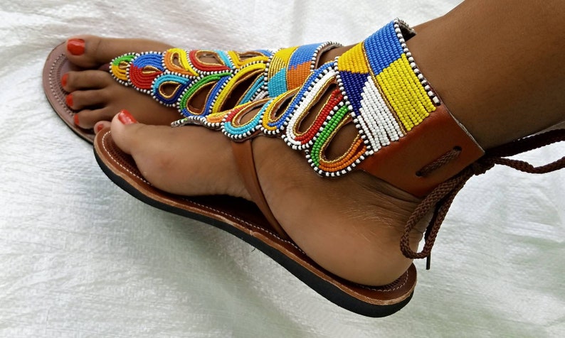 A pair of African Maasai sandals featuring colorful beadwork on soft leather, designed for comfort and style.