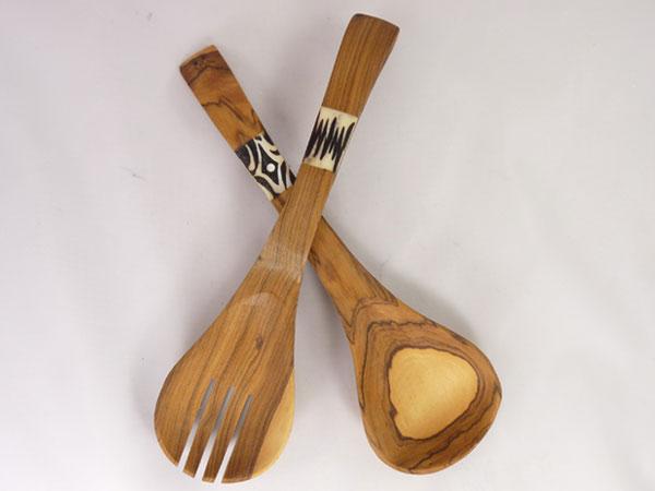 Hand-carved African olive wood salad serving set with batiked bone inlay, showcasing unique patterns and natural wood grain.