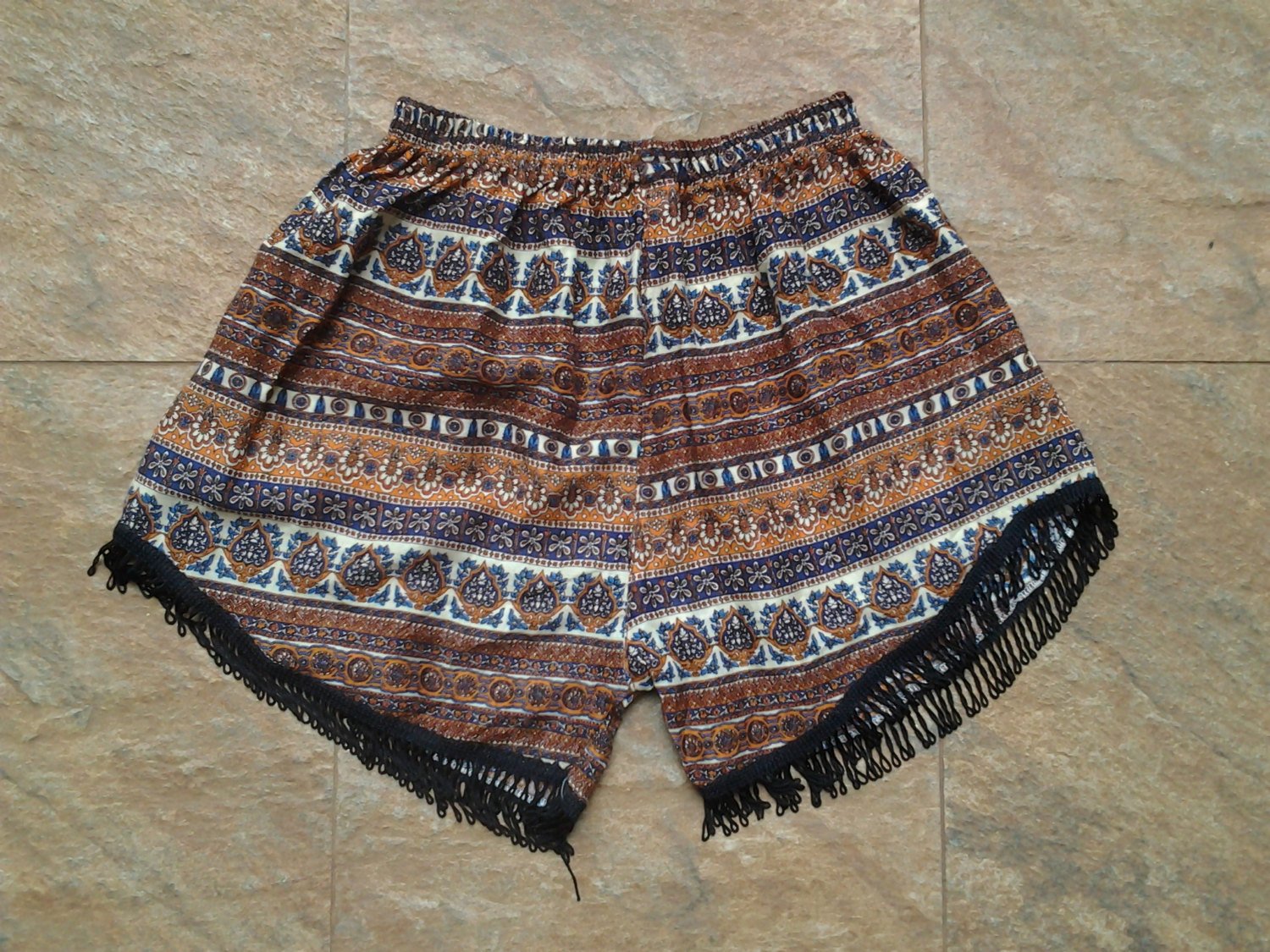 A pair of African short pants featuring a vibrant elephant print, made from lightweight rayon fabric, ideal for beach outings.