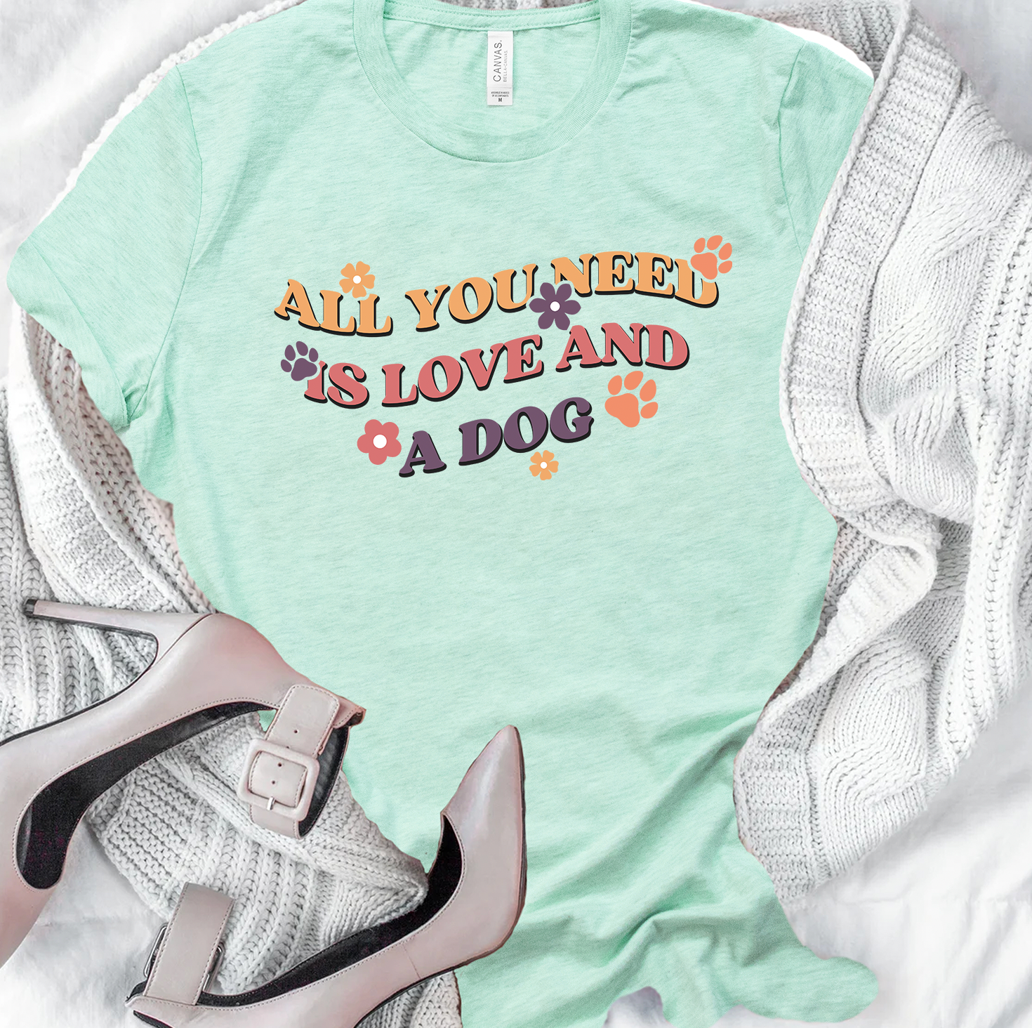 Unisex t-shirt featuring the phrase 'All You Need Is Love and A Dog' with a vibrant design, perfect for dog lovers.