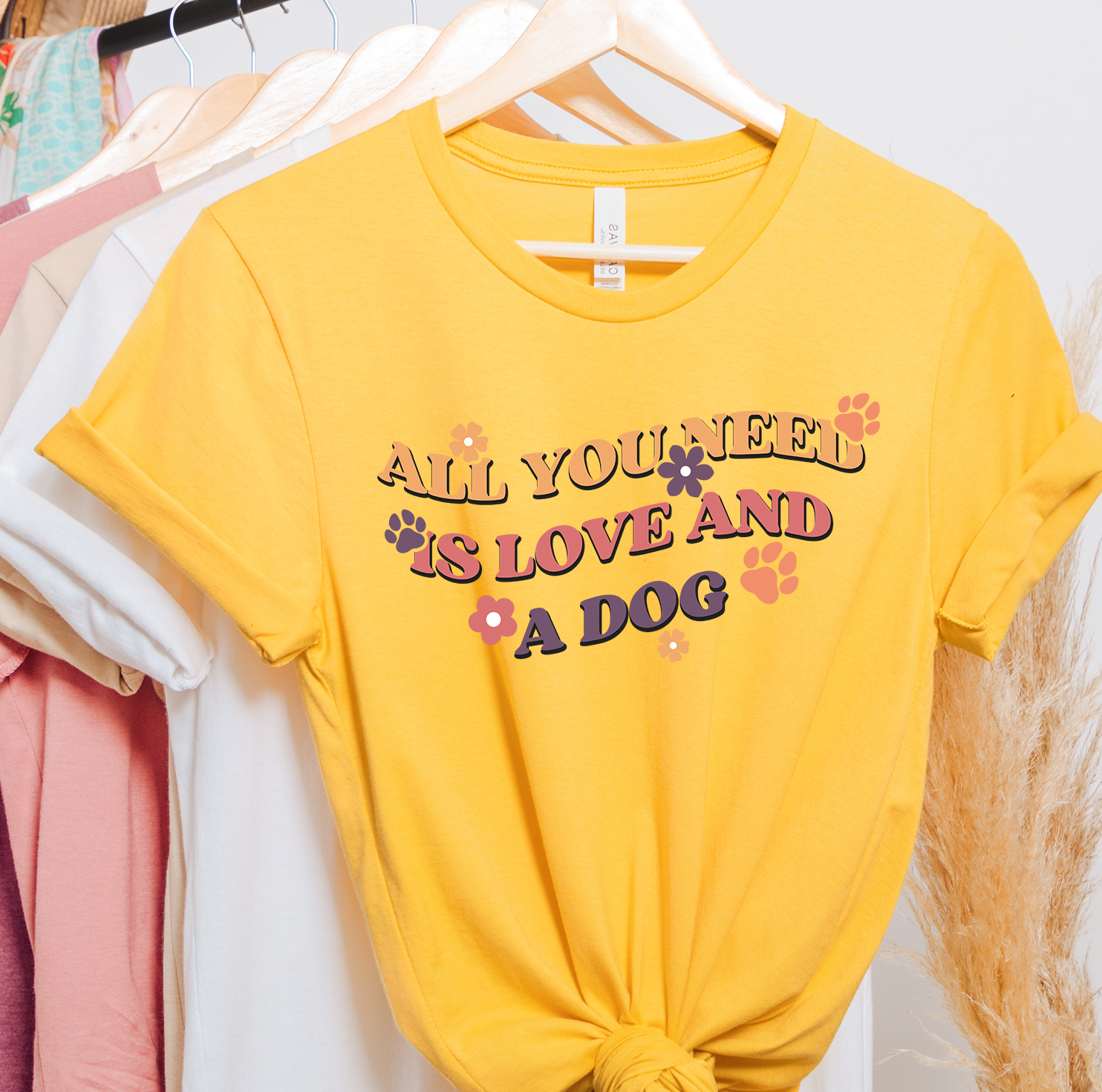 Unisex t-shirt featuring the phrase 'All You Need Is Love and A Dog' with a vibrant design, perfect for dog lovers.