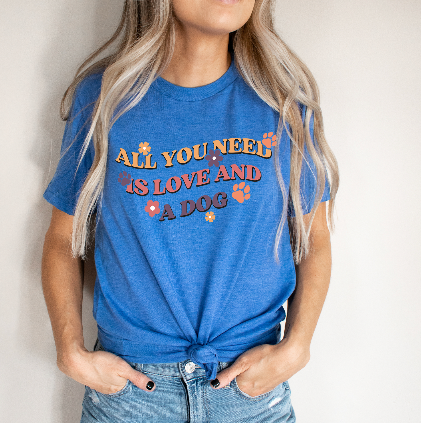 Unisex t-shirt featuring the phrase 'All You Need Is Love and A Dog' with a vibrant design, perfect for dog lovers.