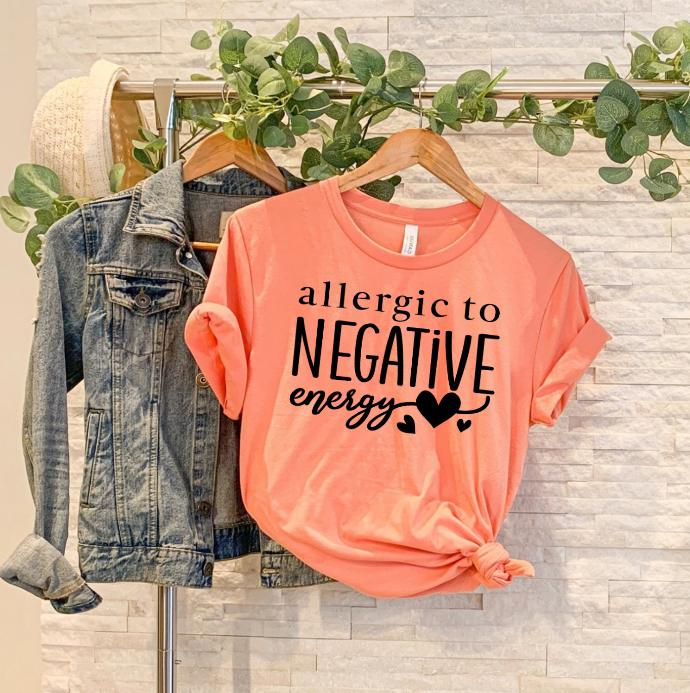 A stylish unisex t-shirt featuring the phrase 'Allergic To Negative Energy' printed in vibrant colors, showcasing a modern design.