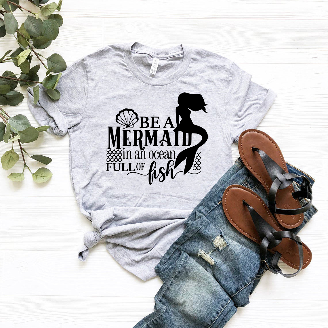 A stylish unisex T-shirt featuring a whimsical mermaid design, crafted from soft ring spun cotton, available in multiple colors.