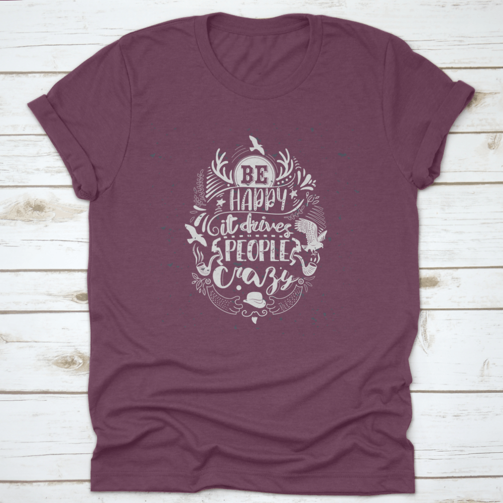 A soft cotton t-shirt featuring the inspirational quote 'Be Happy It Drives People Crazy' in a stylish font, perfect for casual wear.