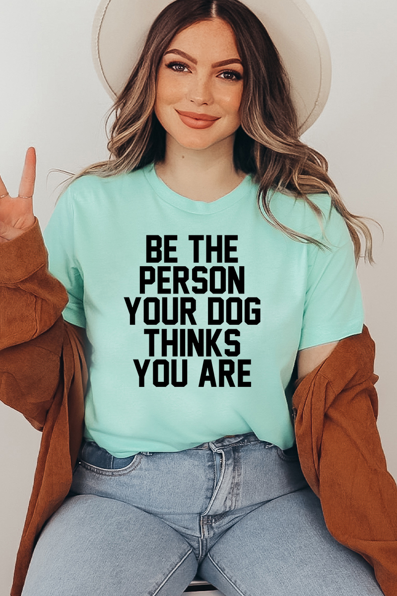 A comfortable unisex T-shirt featuring the phrase 'Be The Person Your Dog Thinks You Are', made from soft ring-spun cotton.