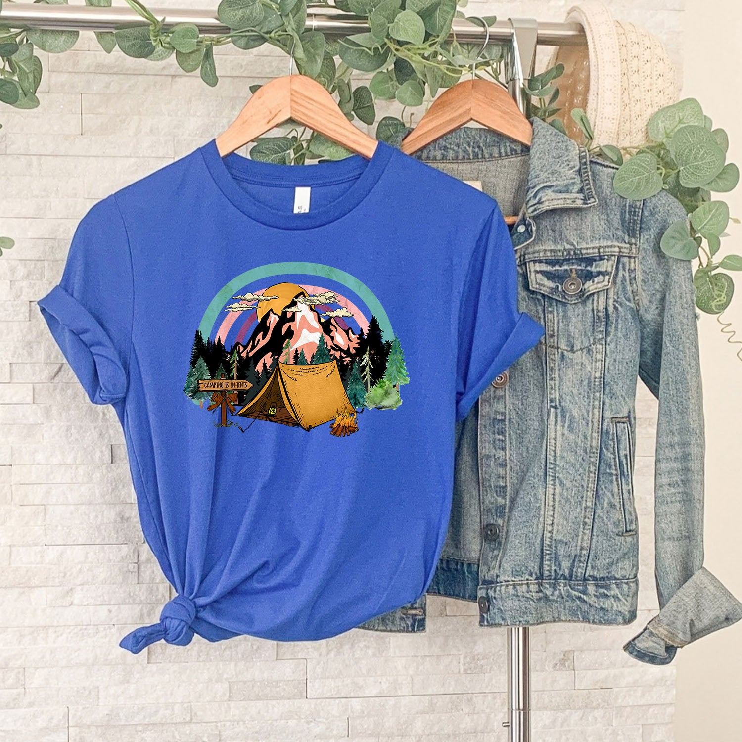 A stylish unisex t-shirt featuring the phrase 'Camping Is in Tents', perfect for outdoor enthusiasts.