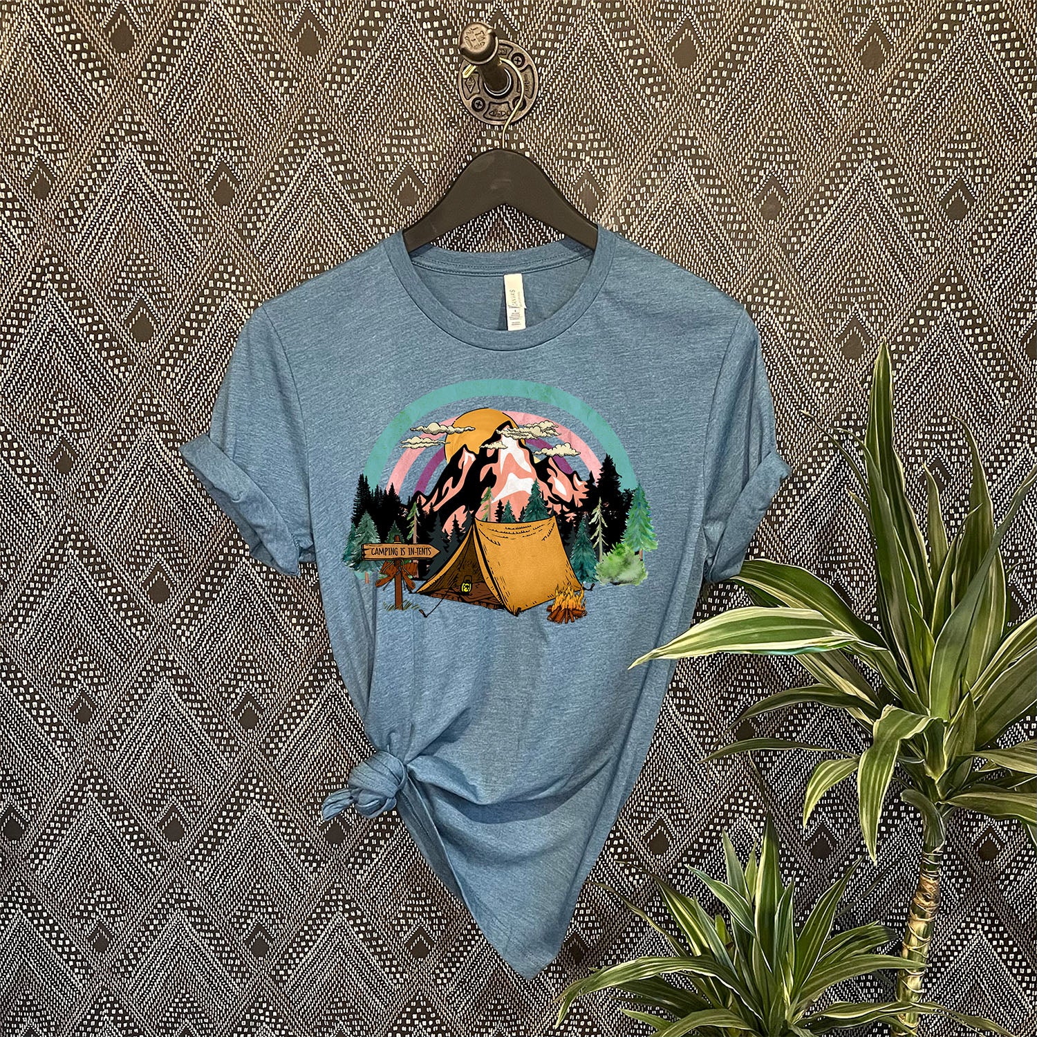 A stylish unisex t-shirt featuring the phrase 'Camping Is in Tents', perfect for outdoor enthusiasts.