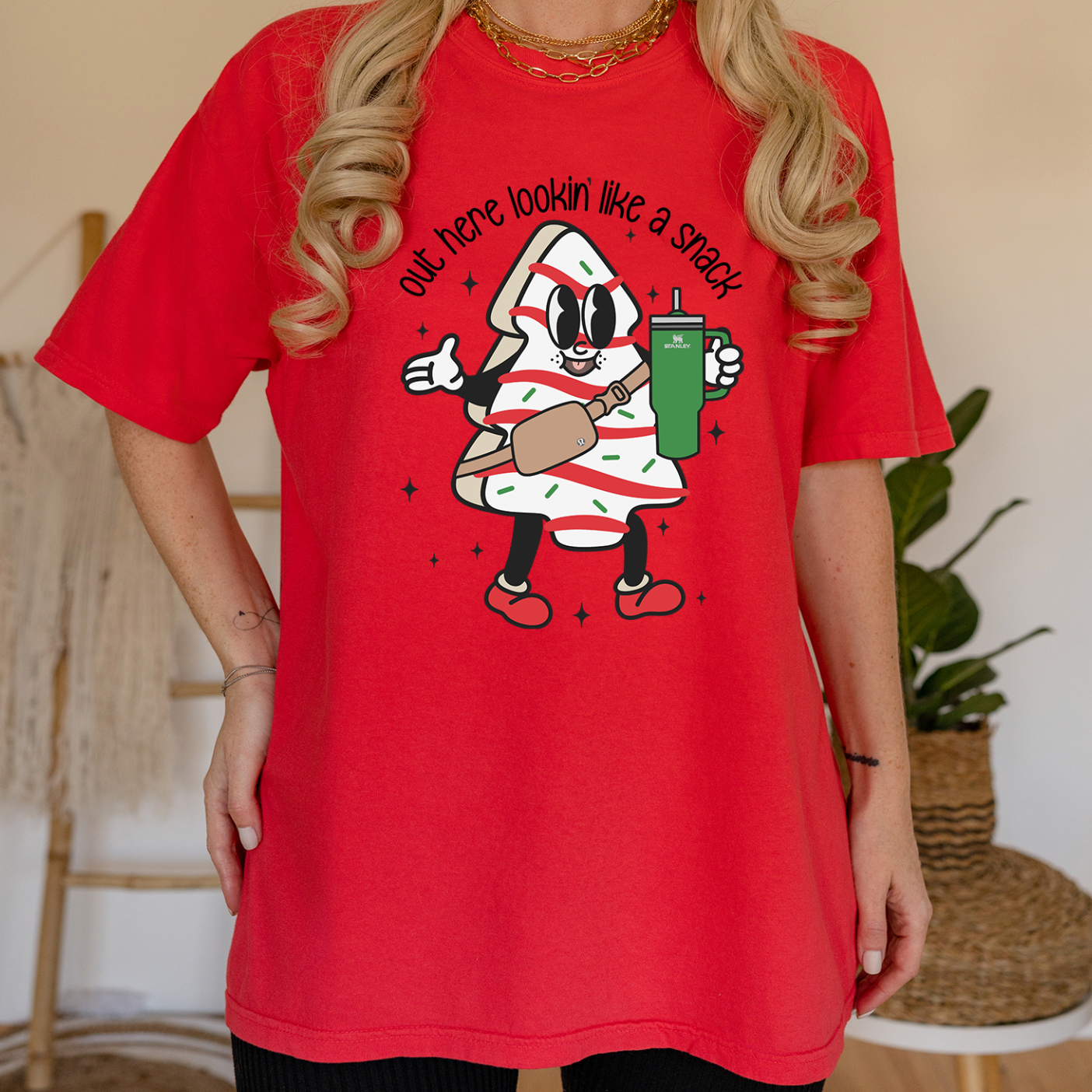 A festive unisex T-shirt featuring the phrase 'Christmas Lookin Like a Snack' printed in vibrant colors on a soft fabric.