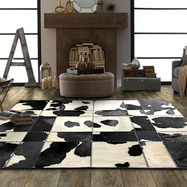 Handmade black and white patchwork cow skin rug, showcasing a luxurious design with natural leather texture.