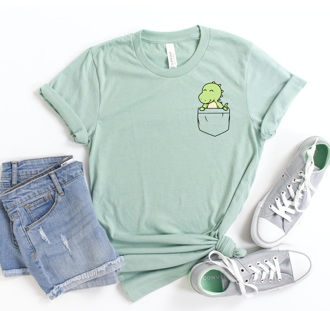 A unisex Dinosaur Pocket T-shirt featuring a playful dinosaur graphic on the pocket, made from soft, high-quality cotton.