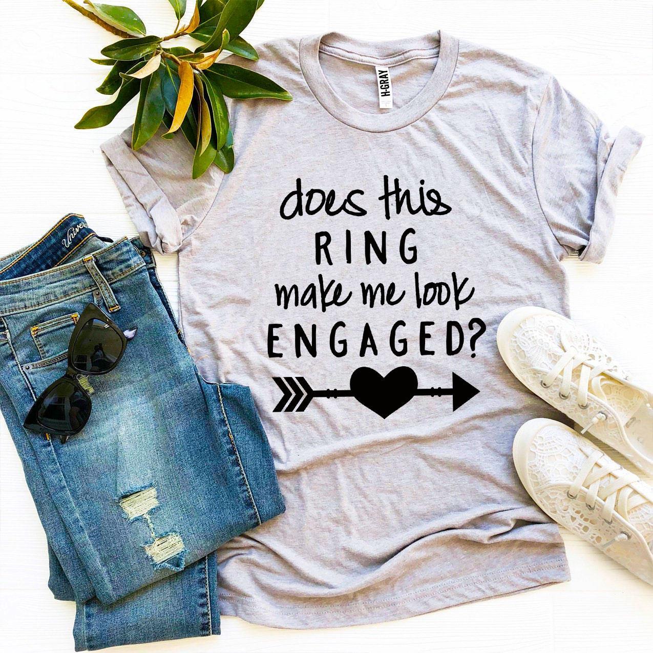 A stylish black T-shirt with the phrase 'Does This Ring Make Me Look Engaged?' printed in white, showcasing a humorous engagement theme.