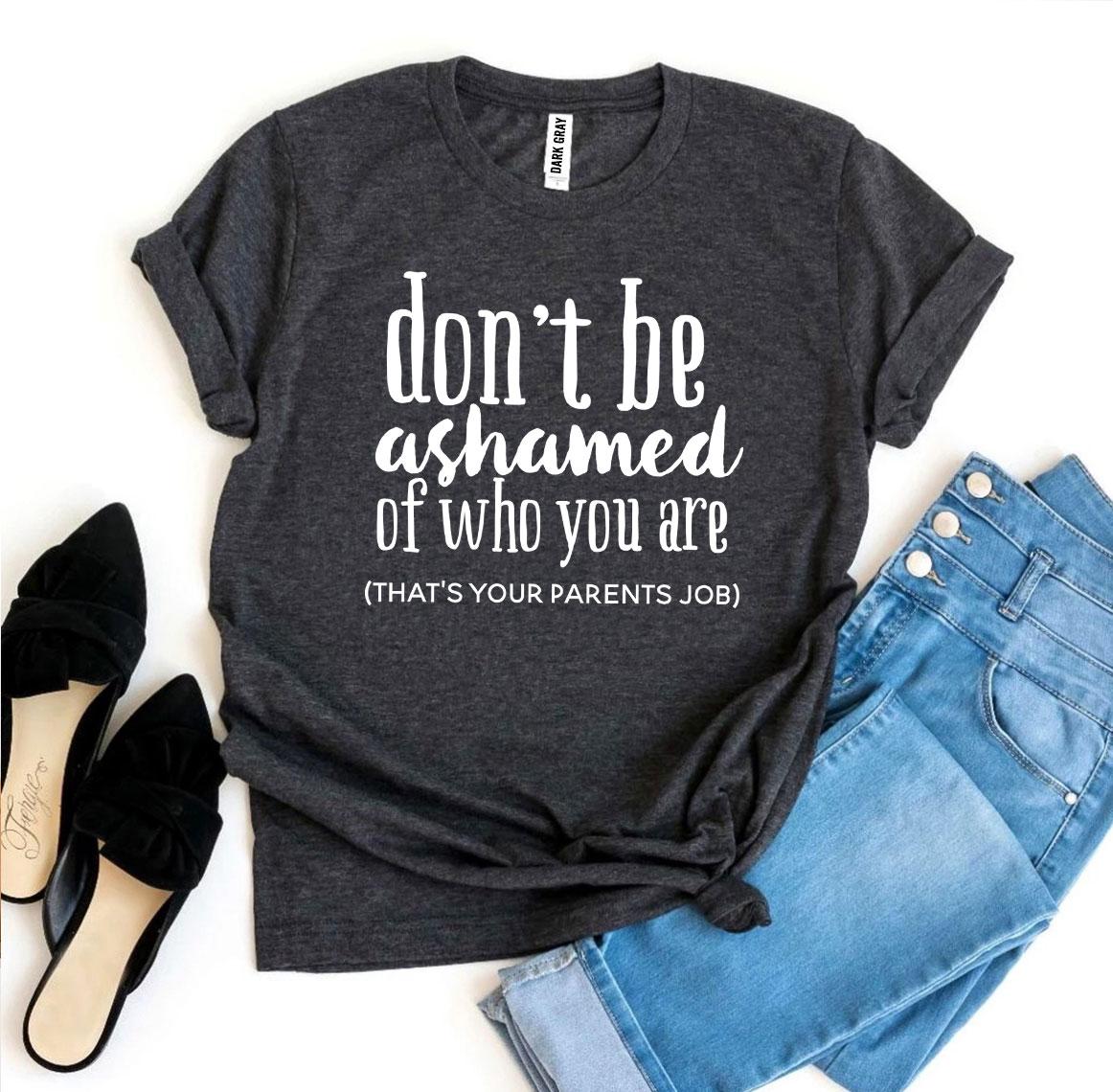 A stylish black t-shirt featuring the phrase 'Don’t Be Ashamed Of Who You Are' in bold print, made from soft ring spun cotton.