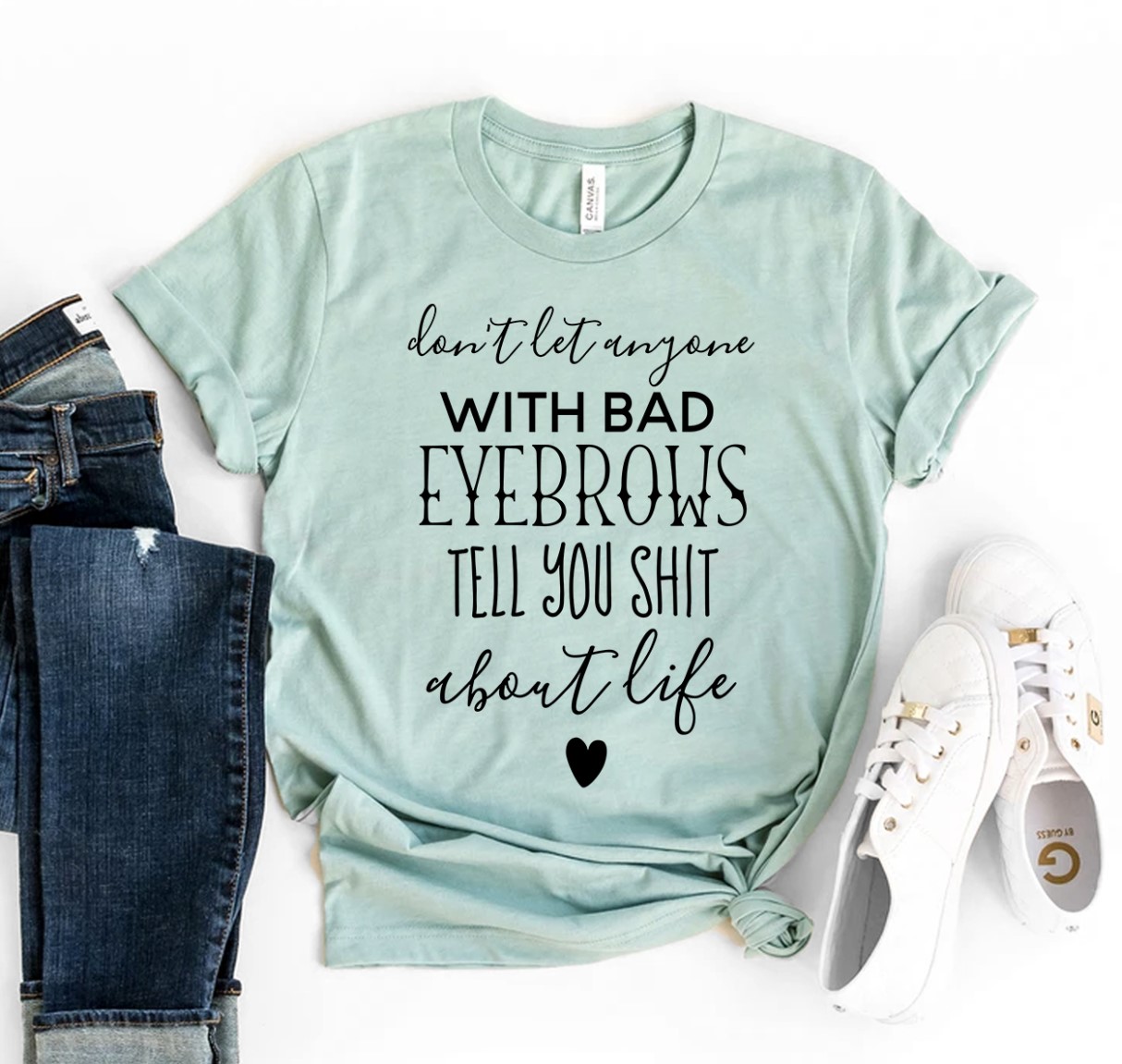 A stylish t-shirt featuring the phrase 'Don’t Let Anyone With Bad Eyebrows' printed in high-quality flex print on a soft ring spun cotton fabric.